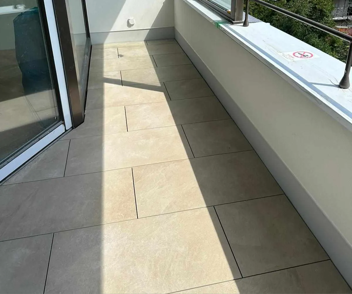 Moderner Balkon mit großformatigen Fliesen und Glasgeländer